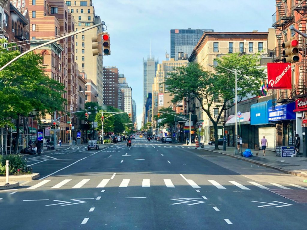 A New York City street with people walking among neighborhood storefronts