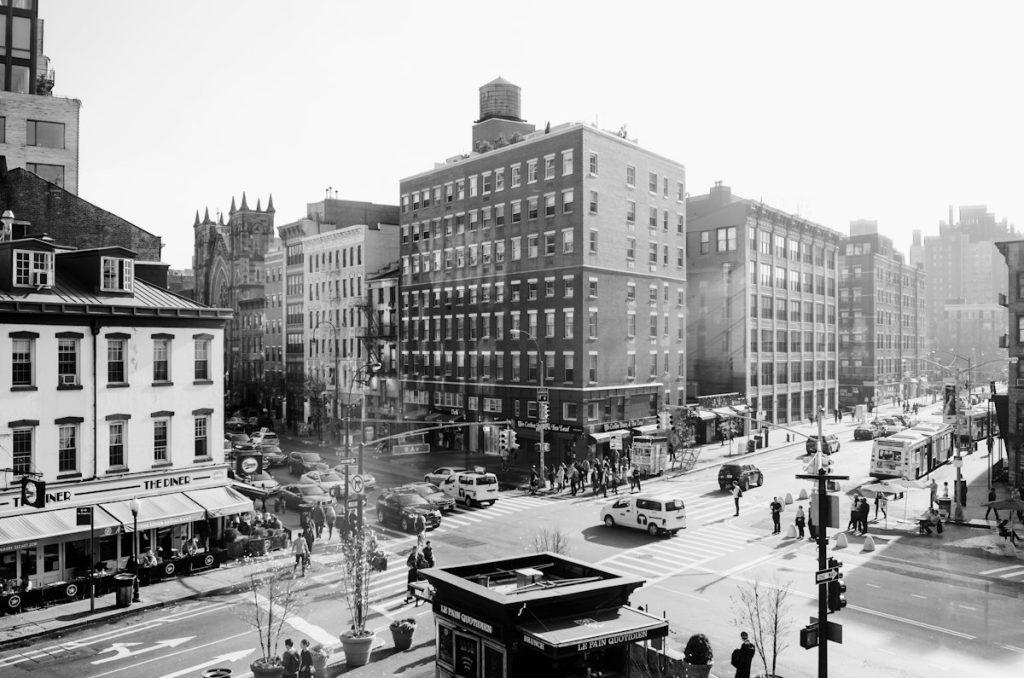 Historic-looking New York street with older buildings and cars, evoking neighborhood change over time